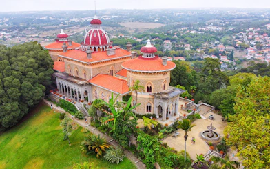 Aerial view of Monserrate Palace in Sintra, Portugal, surrounded by lush gardens and greenery.