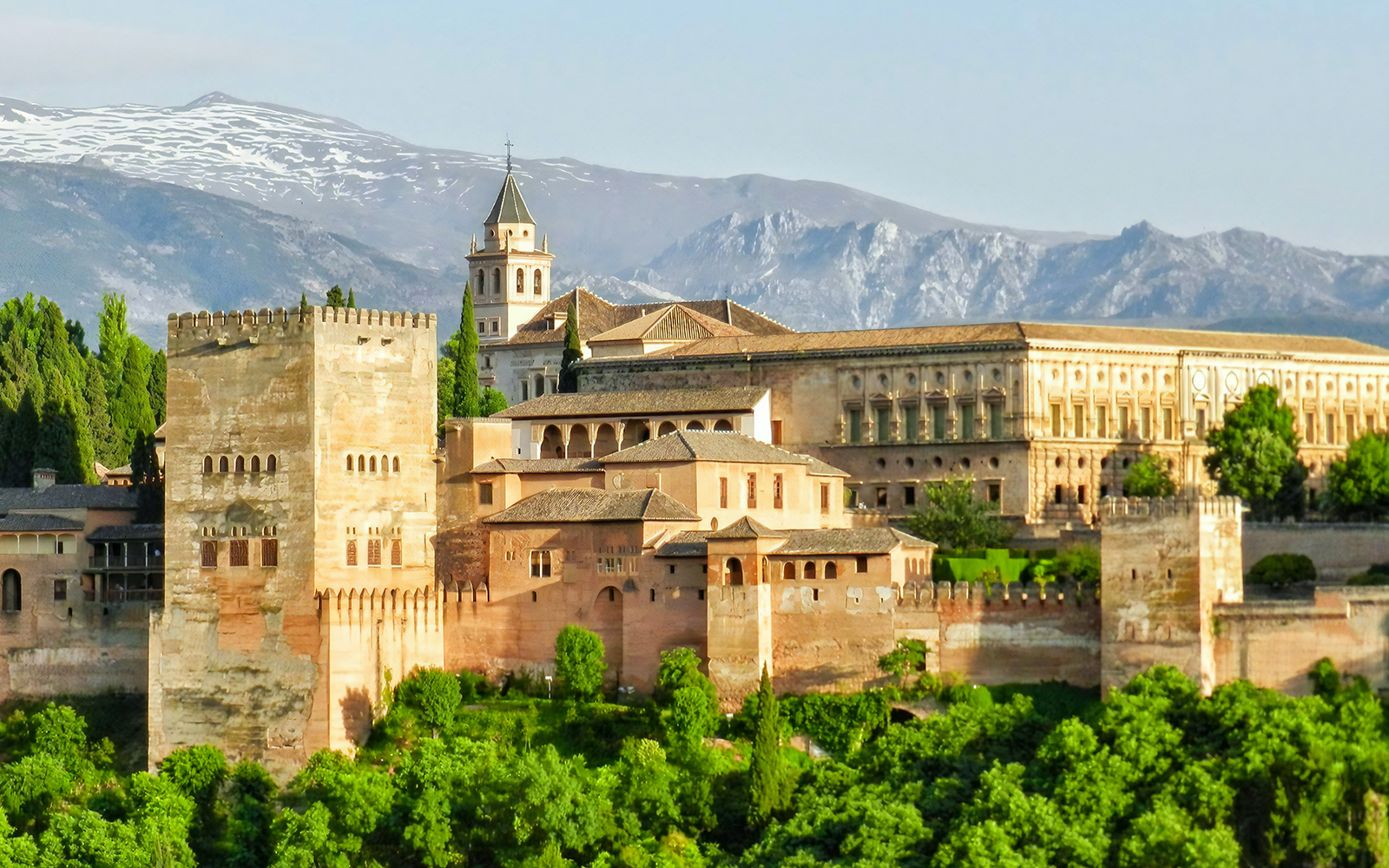 Panoramic view of Alhambra Palace in Granada with Sierra Nevada mountains in the background.