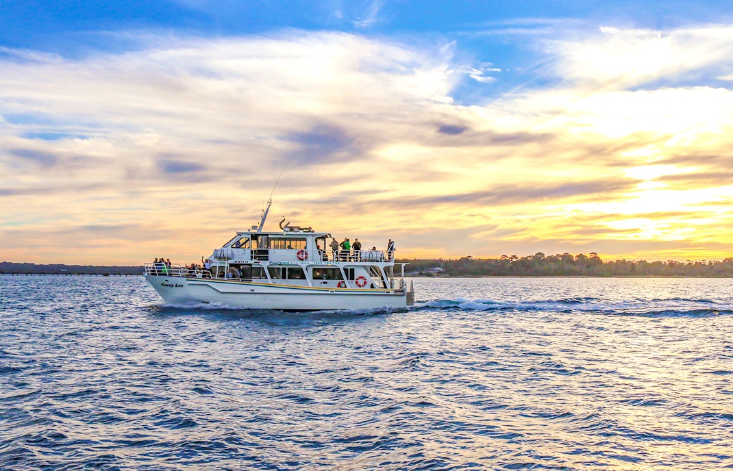 Phillip Island cruise boat on water with scenic coastal view, Melbourne, Australia.