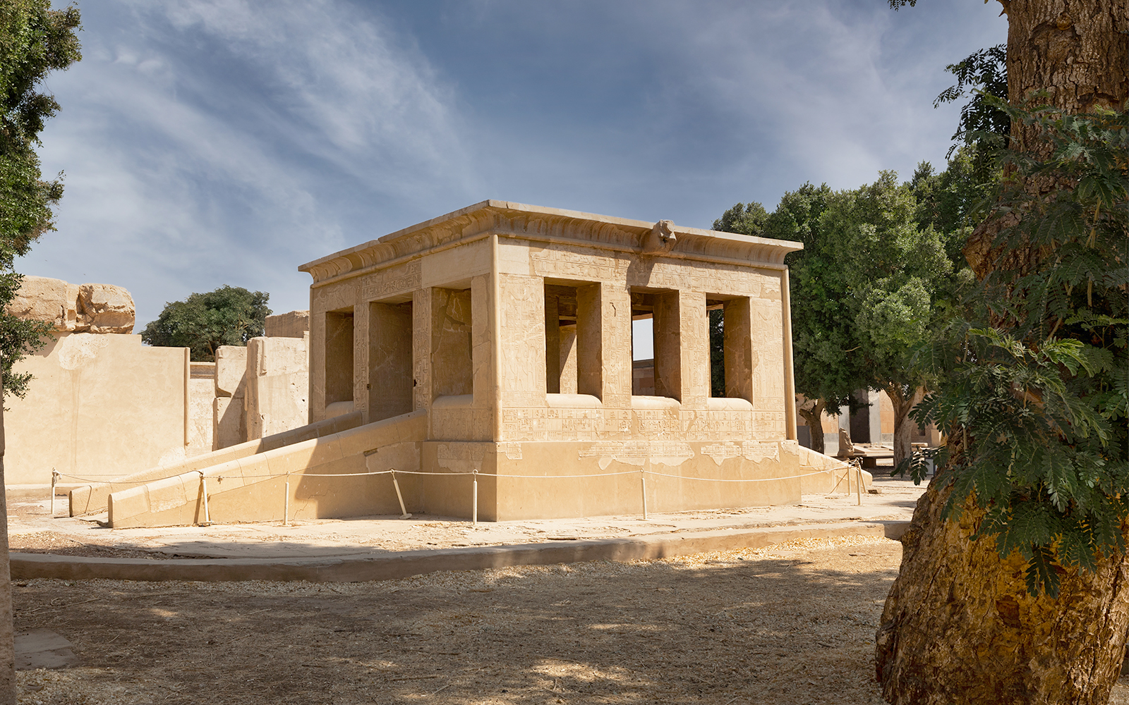 Karnak Temple ruins with hieroglyphs, surrounded by trees, Luxor, Egypt.
