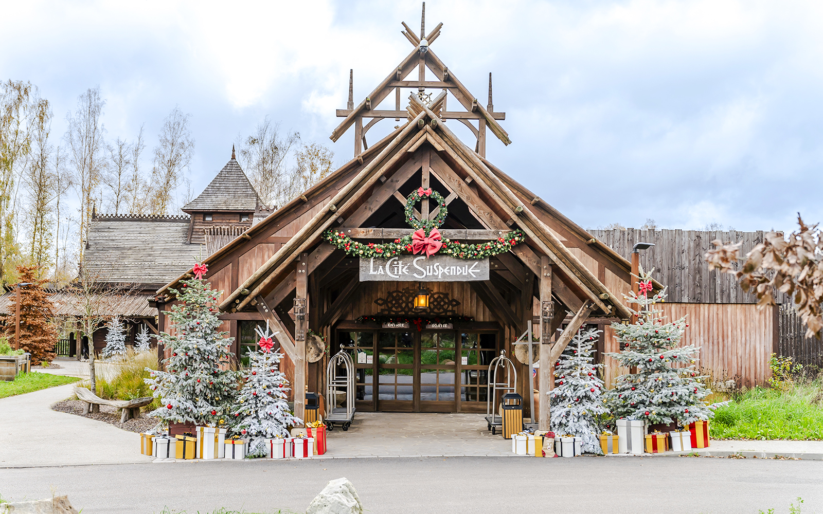 Parc Asterix entrance decorated with Christmas trees and gifts during holiday celebrations.