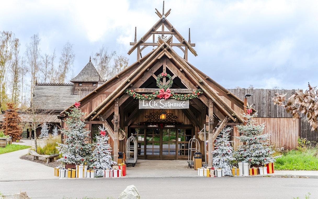 Parc Asterix entrance decorated with Christmas trees and gifts during holiday celebrations.