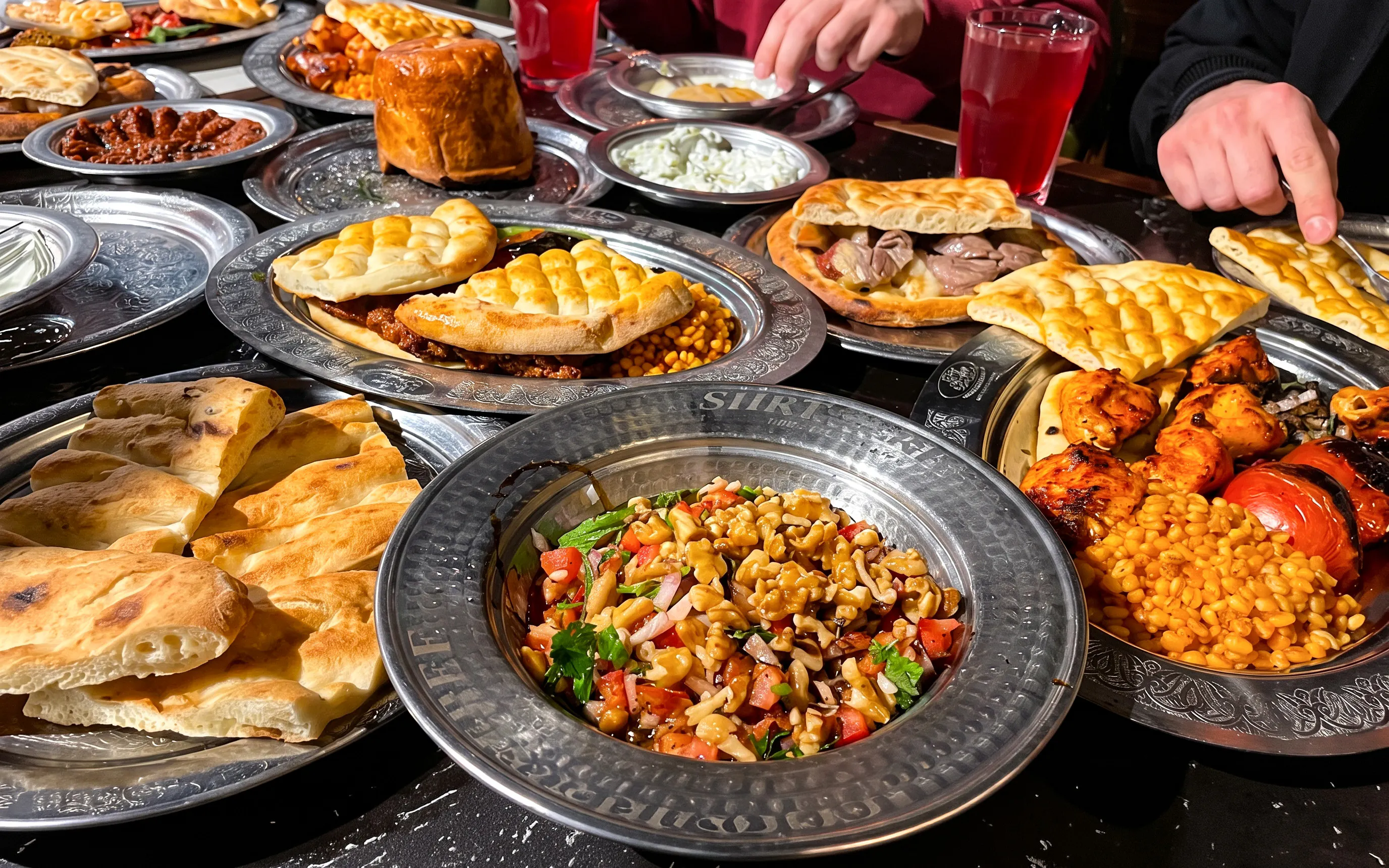 Turkish dishes on a table during a food night in Istanbul, featuring kebabs, bread, and salads.