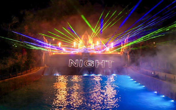 Siam Park illuminated at night with vibrant water slides and palm trees in Tenerife, Spain.