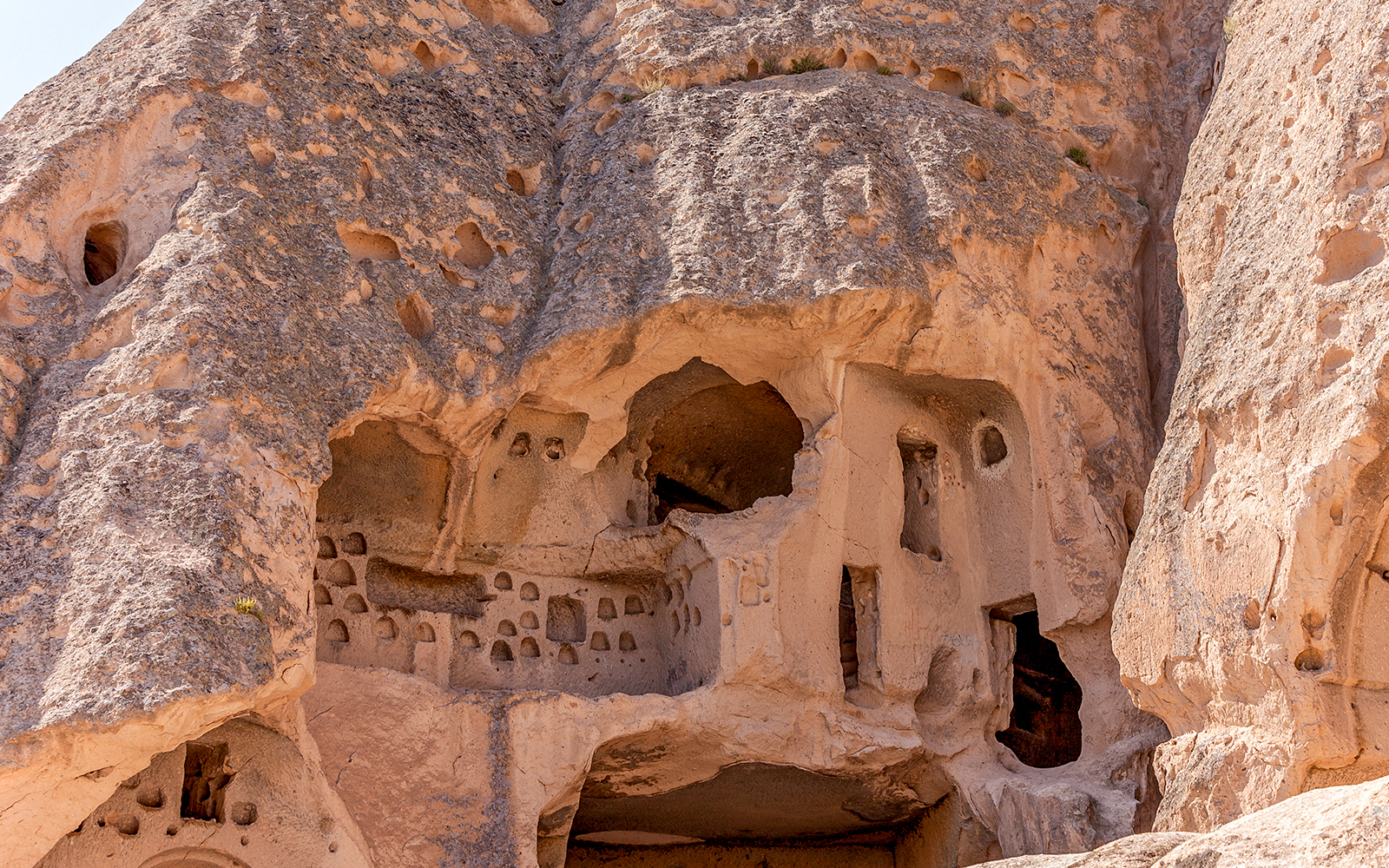 Ancient rock-cut dwellings in Cappadocia, Turkey, showcasing unique geological formations.