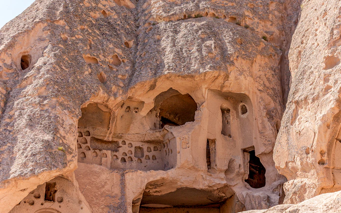 Ancient rock-cut dwellings in Cappadocia, Turkey, showcasing unique geological formations.