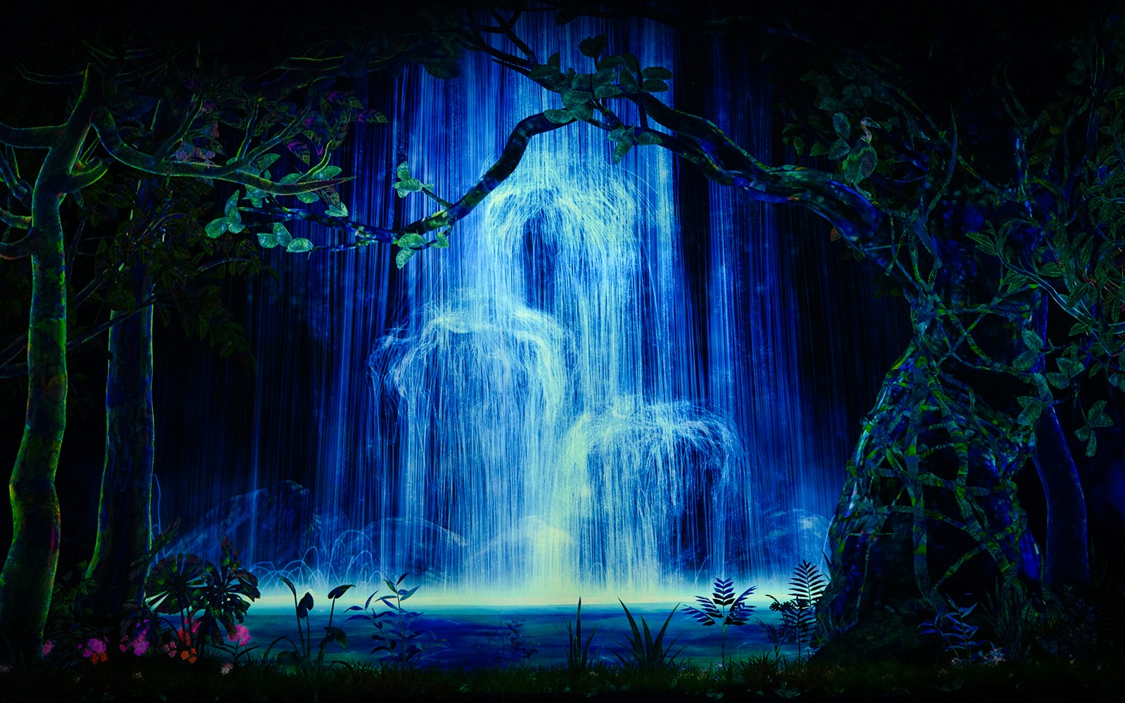 Abstract art installation with blue waterfall and surrounding foliage.