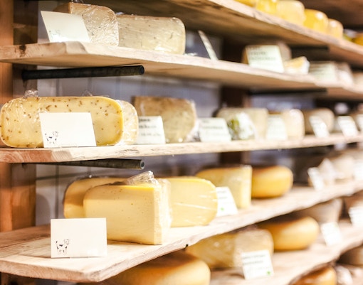 Assorted cheeses on wooden shelves