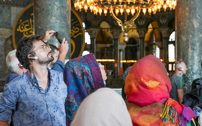 Visitors using audio guides inside Hagia Sophia, Istanbul.