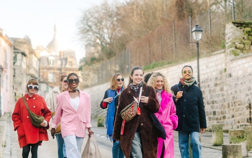 Group walking in Montmartre, Paris, with Sacré-Cœur in the background on a guided tour.
