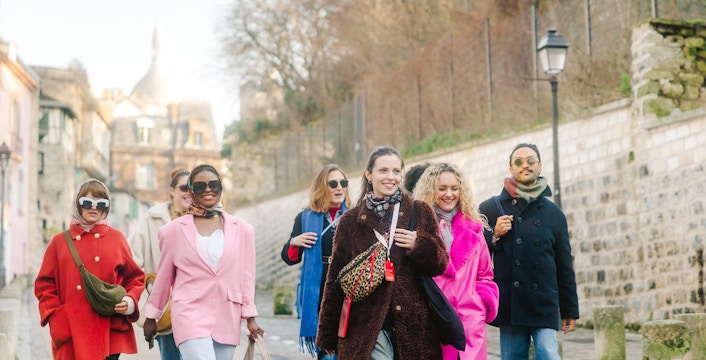 Group walking in Montmartre, Paris, with Sacré-Cœur in the background on a guided tour.
