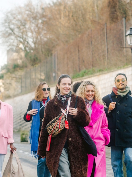 Group walking in Montmartre, Paris, with Sacré-Cœur in the background on a guided tour.
