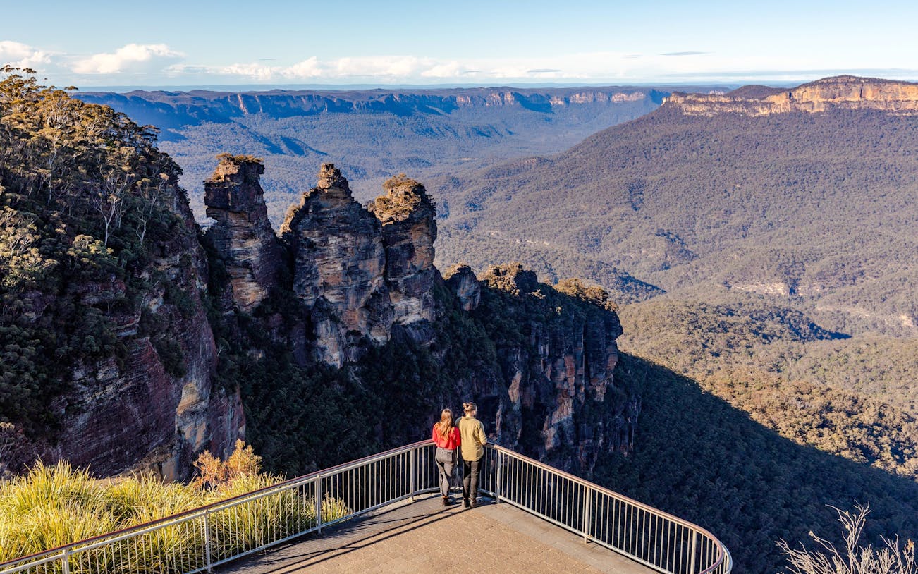Couple viewing the Three Sisters rock formation in Blue Mountains, Australia.