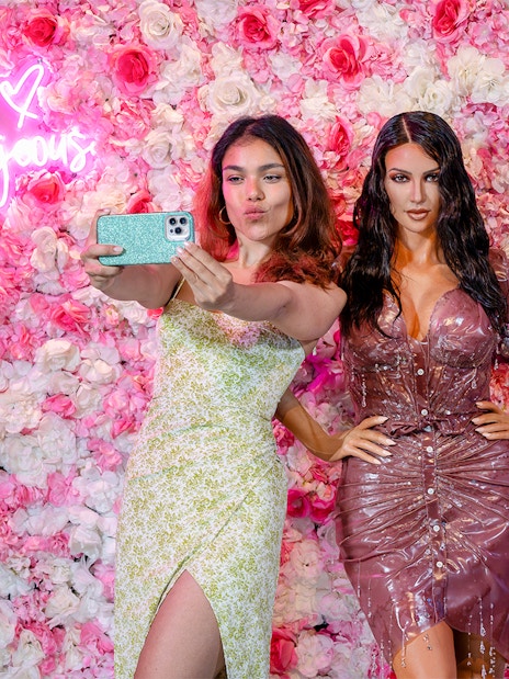 Woman taking selfie with wax figure at Madame Tussauds, New York.