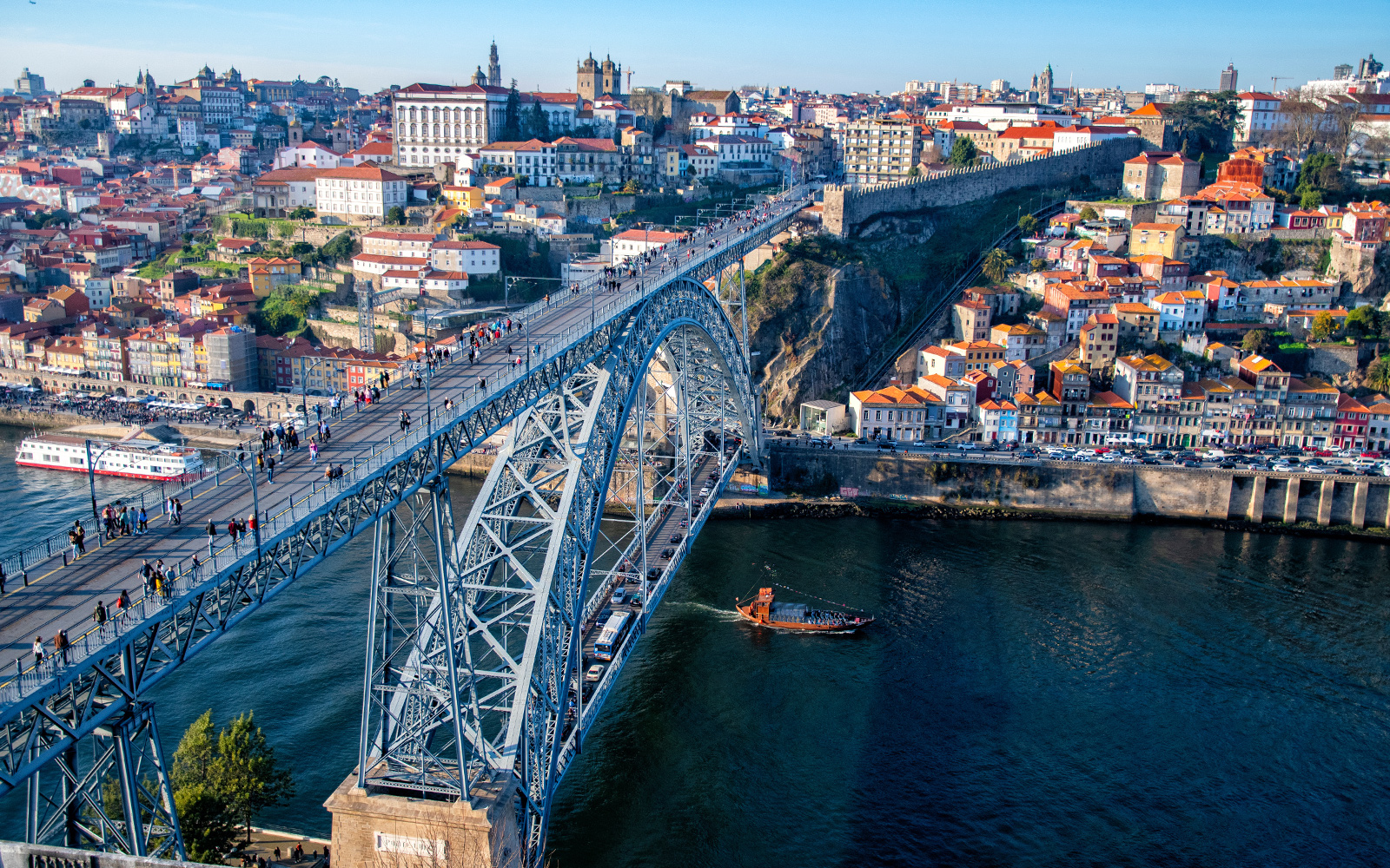 Dom Luís I Bridge spanning the Douro River in Porto, Portugal, with cityscape in the background.