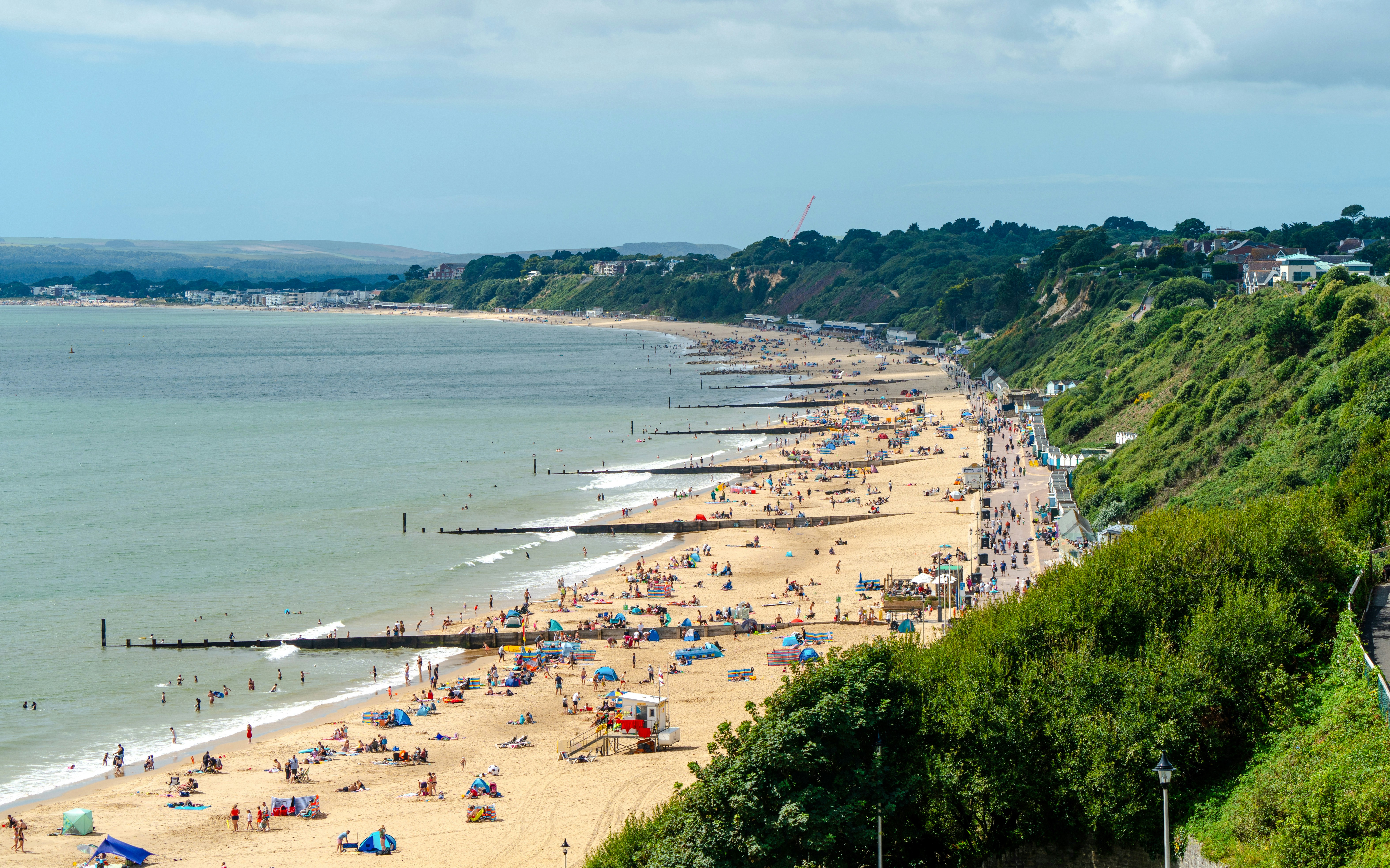 Sandbanks beach in Bournemouth with visitors enjoying the sandy shoreline and ocean views.