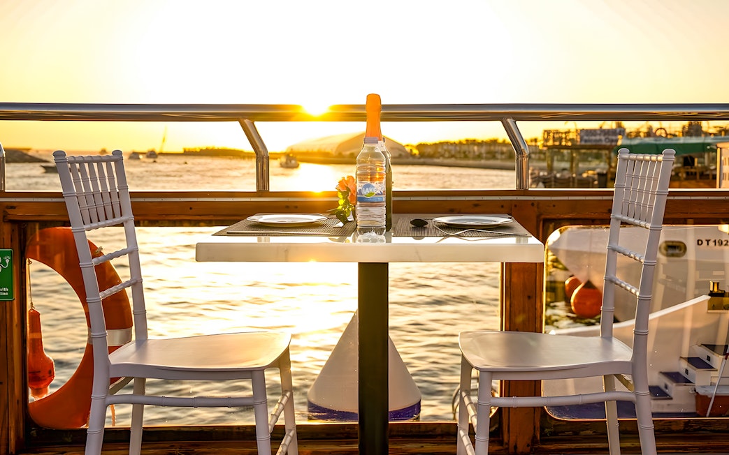 Dinner table on a dhow cruise at sunset, Dubai Marina.