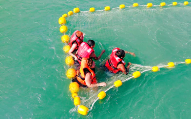 People enjoying water activities in life jackets during Langkawi sunset cruise.