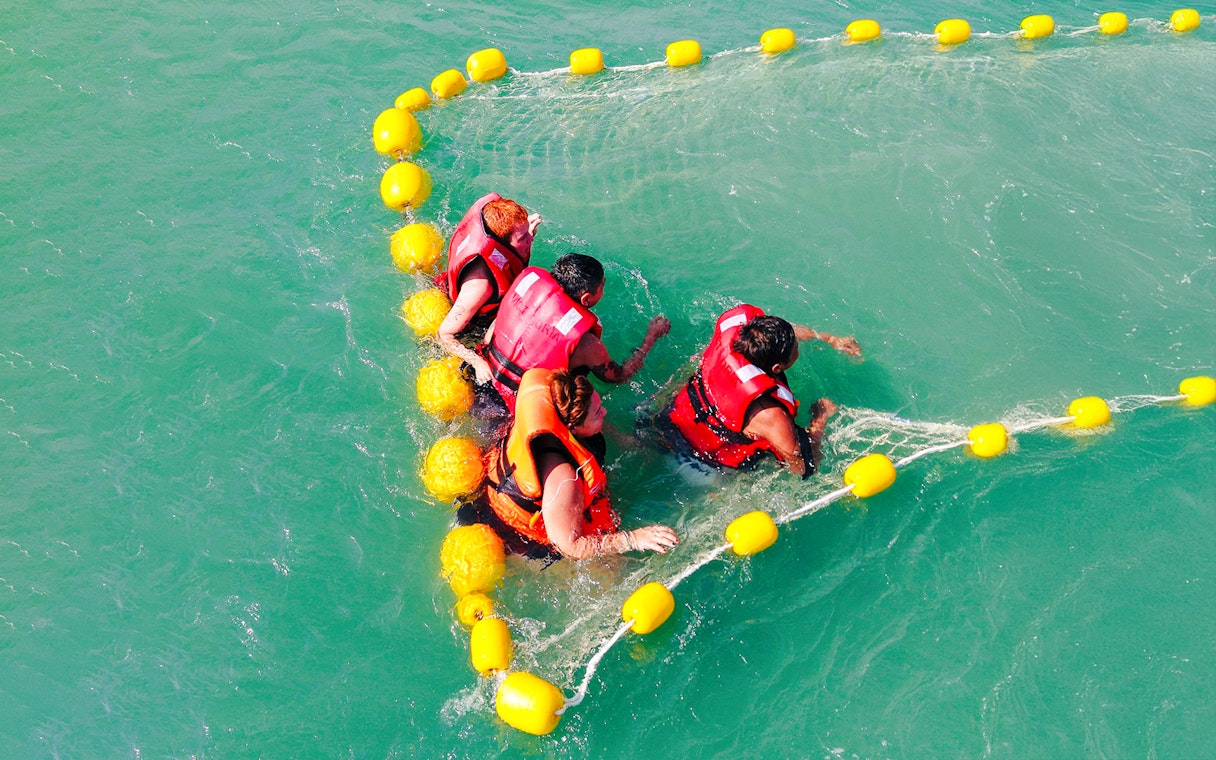 People enjoying water activities in life jackets during Langkawi sunset cruise.