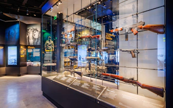Firearms exhibit at the National Navy SEAL Museum, San Diego, showcasing historical weapons and informational displays.