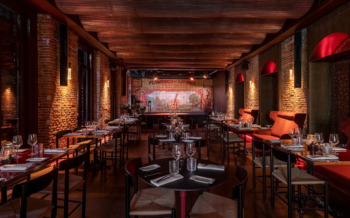 Flamenco De Leones Show venue with tables set for dining, stage in background.