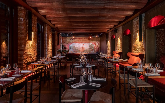 Flamenco De Leones Show venue with tables set for dining, stage in background.