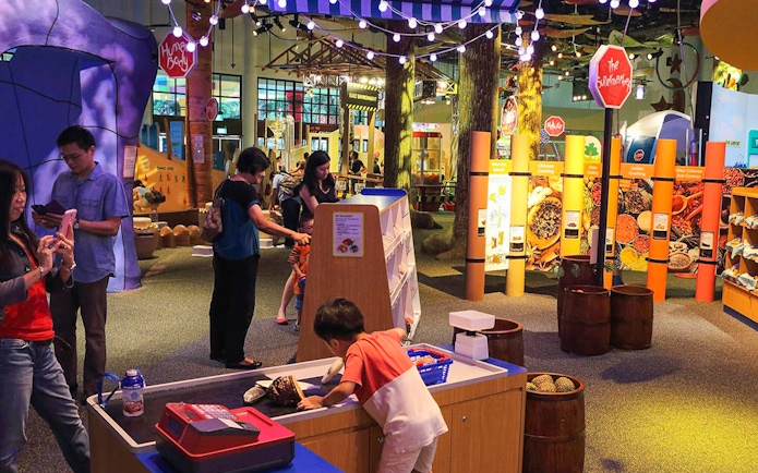 Interactive exhibit at Science Centre Singapore with visitors exploring displays.