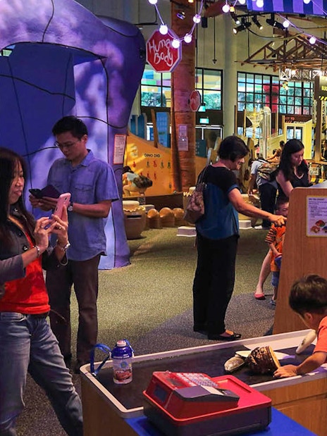 Interactive exhibit at Science Centre Singapore with visitors exploring displays.