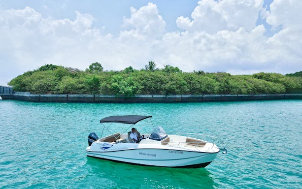 Boat cruising near lush island, part of Cruise And Dine experience.