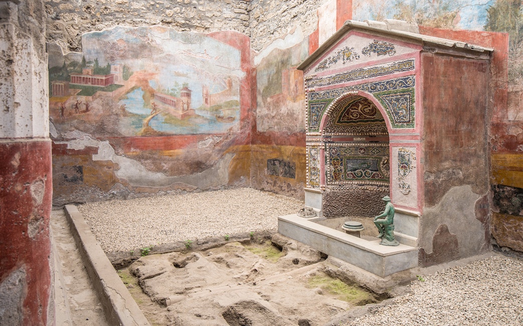 Ancient frescoes and mosaic shrine in the interiors of Pompeii ruins, Italy.