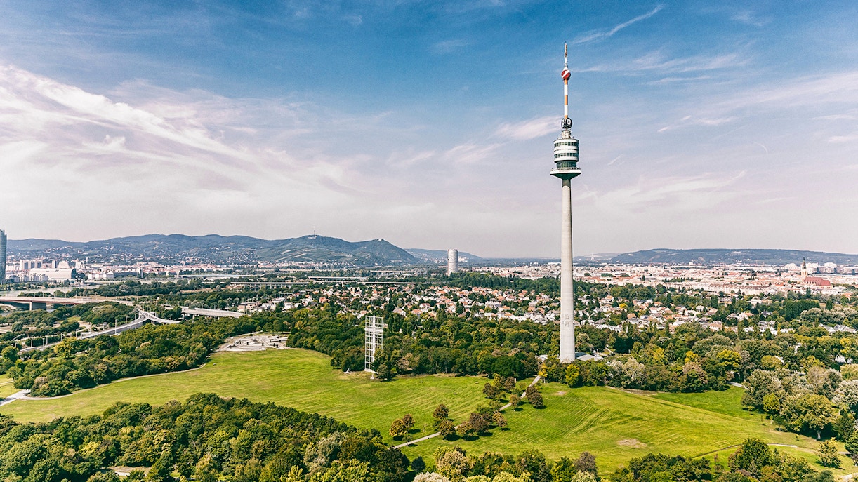 View from Danube Tower in Vienna, Austria, overlooking the cityscape and lush greenery.