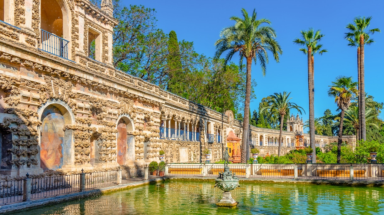 Mercury fountain in Real Alcazar de Sevilla courtyard, Spain, with intricate architectural details.