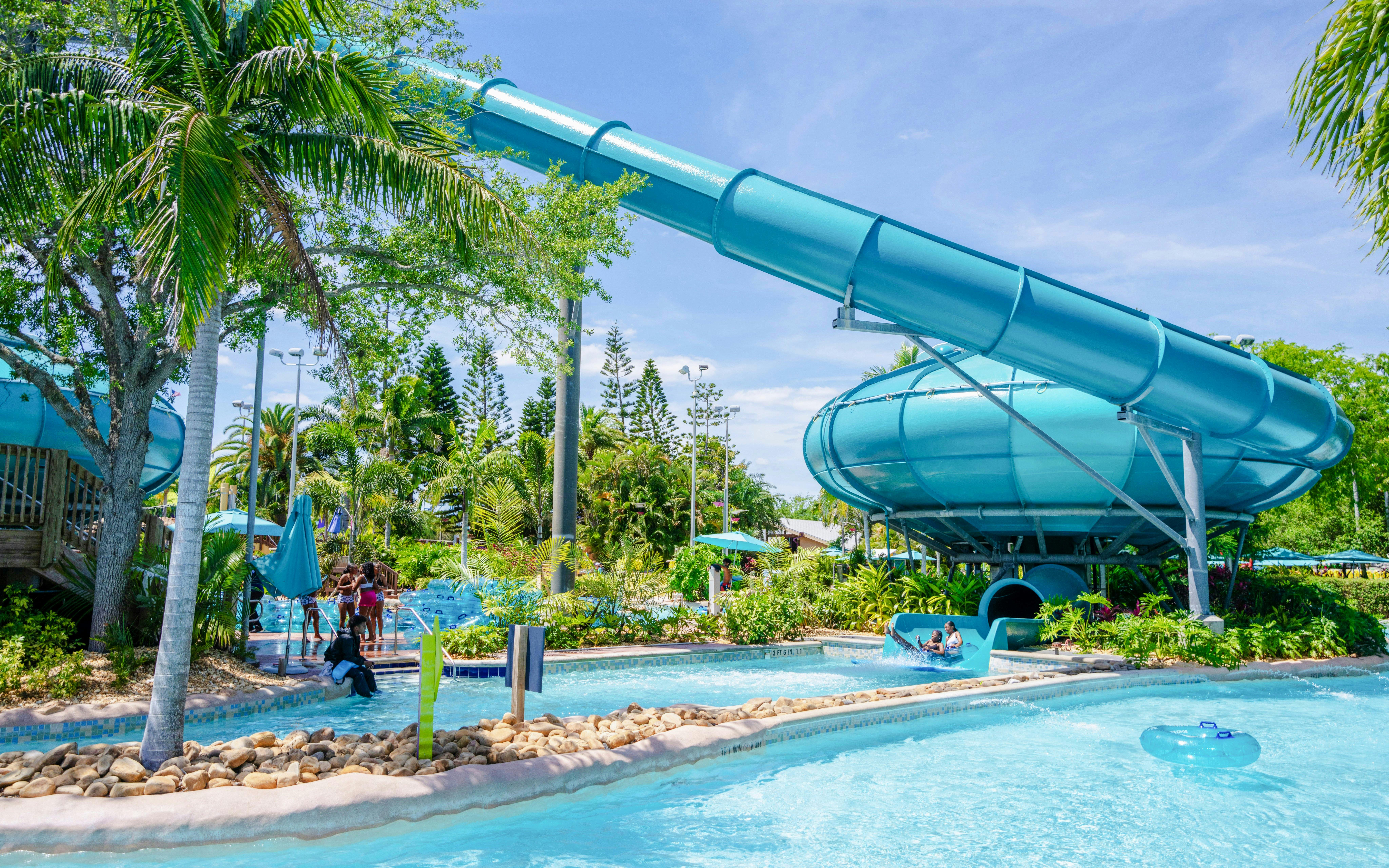 Water slide and lazy river at Aquatica Orlando with lush greenery.