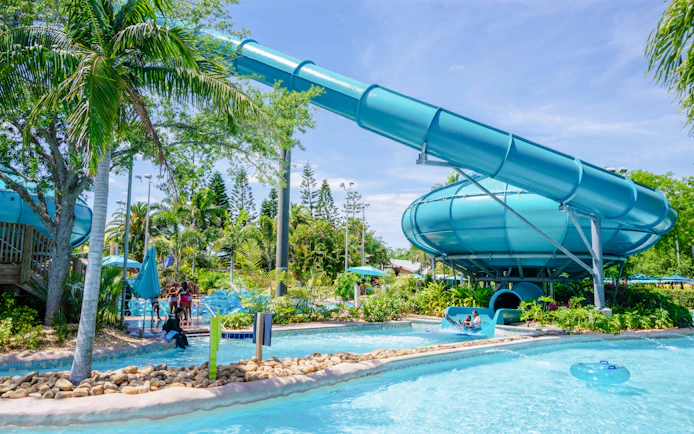 Water slide and lazy river at Aquatica Orlando with lush greenery.