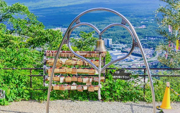 Heart-shaped arch with bell and love locks at Mt Fuji Ropeway viewpoint.