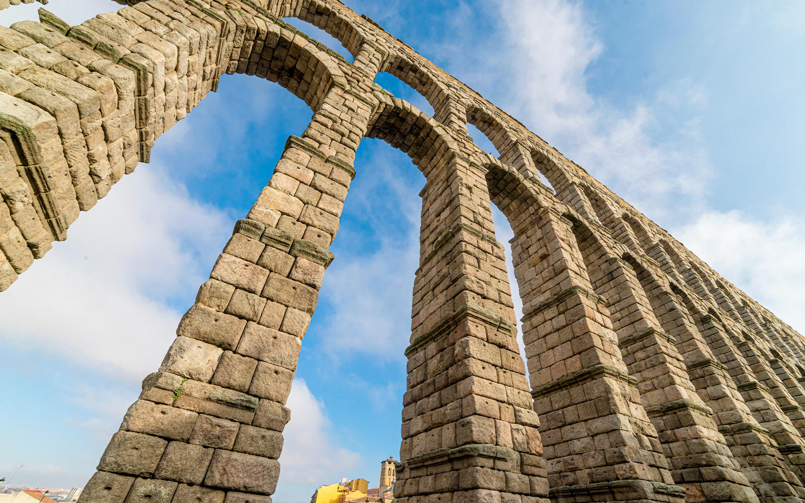 Segovia Aqueduct stone arches against blue sky.