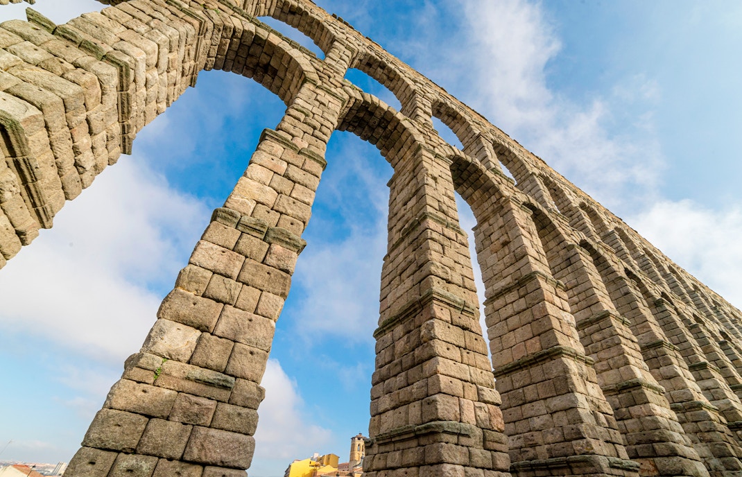 Segovia Aqueduct stone arches against blue sky.