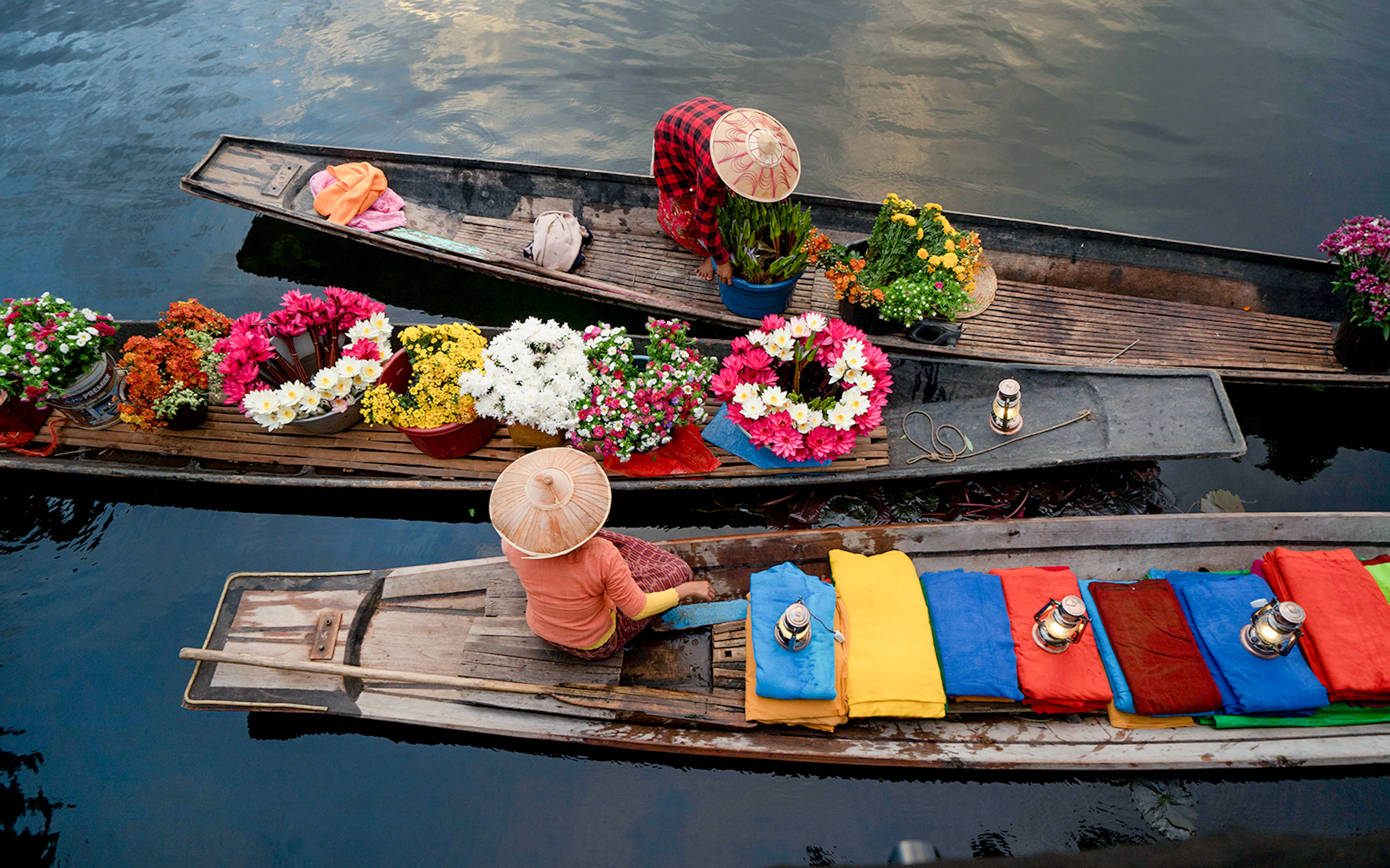 Amphawa floating market boats with vendors selling goods on a canal in Thailand.