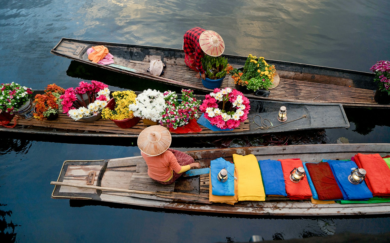 Amphawa floating market boats with vendors selling goods on a canal in Thailand.