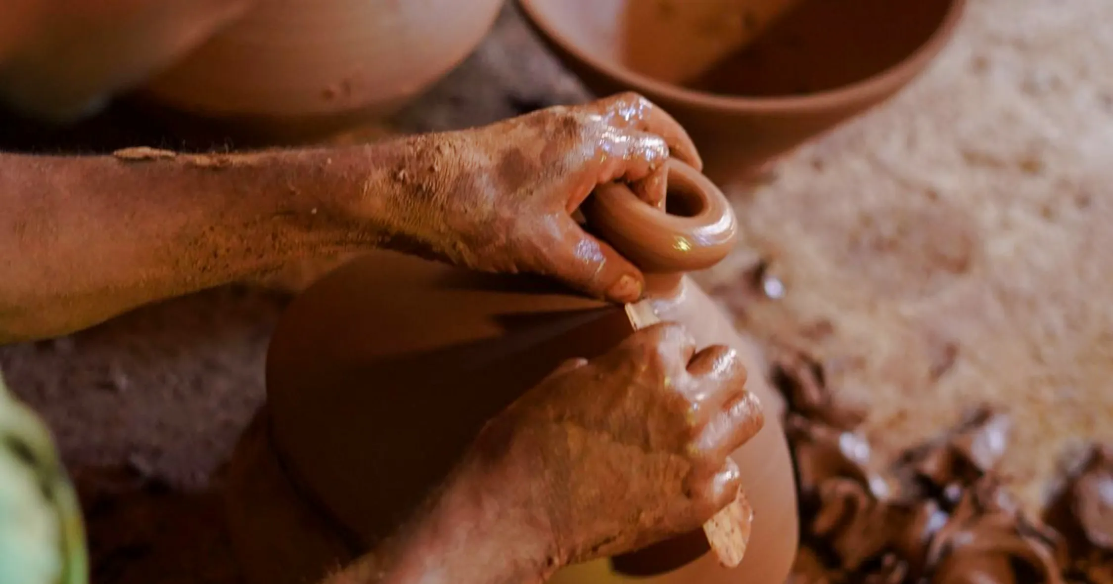 Hands shaping clay at an ancestral pottery workshop near Essaouira.