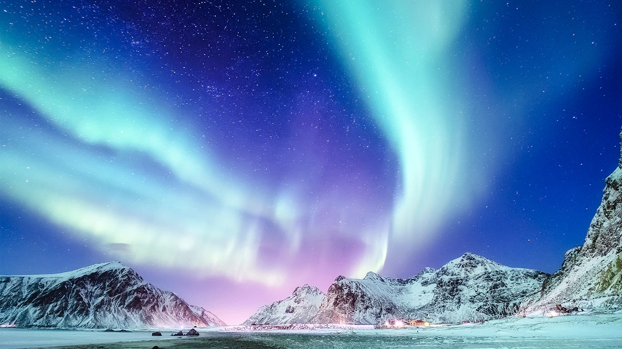 Northern Lights over snowy mountains near Reykjavik.