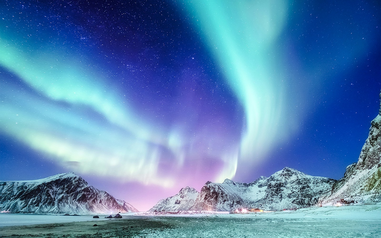 Northern Lights over snowy mountains near Reykjavik.
