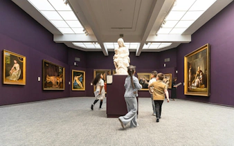 Visitors exploring art exhibits at Groeningemuseum, Bruges.