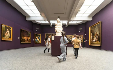 Visitors exploring art exhibits at Groeningemuseum, Bruges.