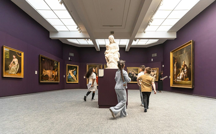 Visitors exploring art exhibits at Groeningemuseum, Bruges.