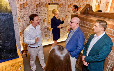 Visitors in a room with Egyptian hieroglyphs during the Tomb of the Pharaoh tour in Cairns, Australia.