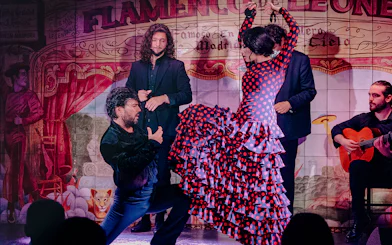 Flamenco dancers performing at Flamenco De Leones Show with guitarist in Madrid.