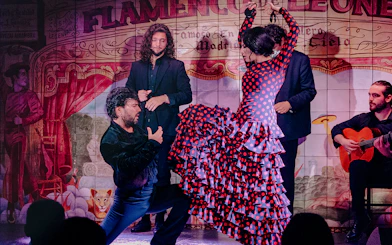Flamenco dancers performing at Flamenco De Leones Show with guitarist in Madrid.
