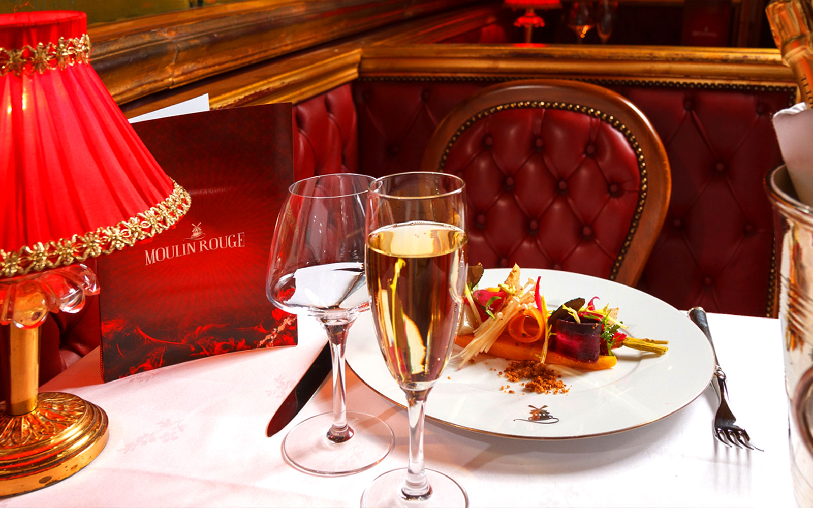 Moulin Rouge tables set for dinner with stage view in Paris, France.