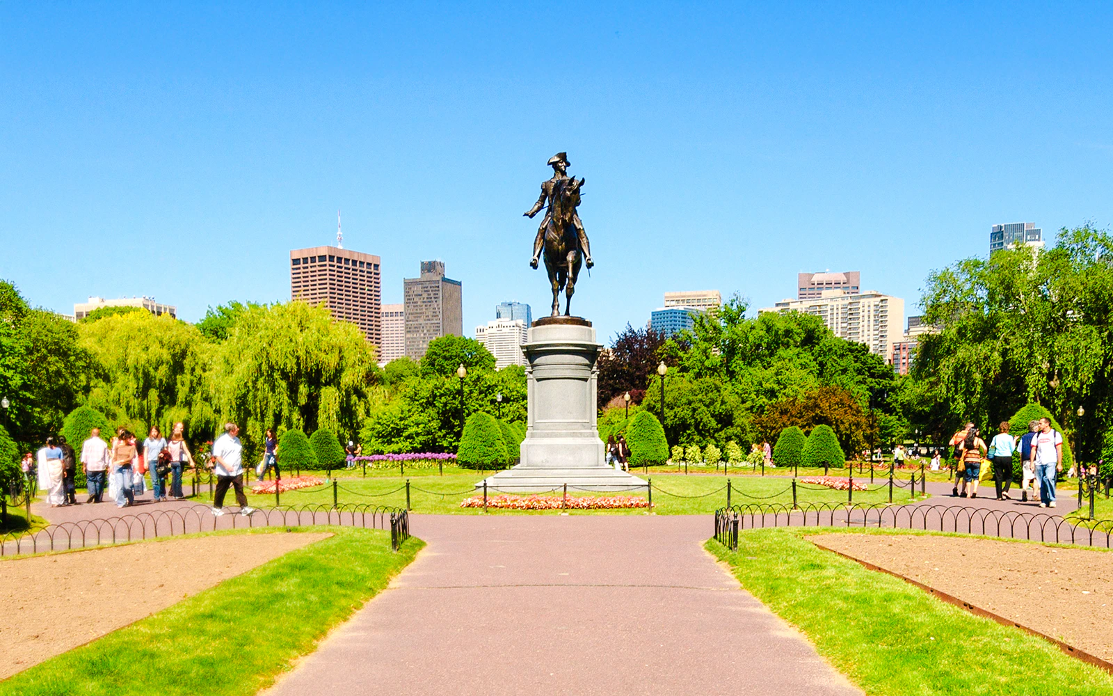 Equestrian statue in Boston Common with city skyline in the background.